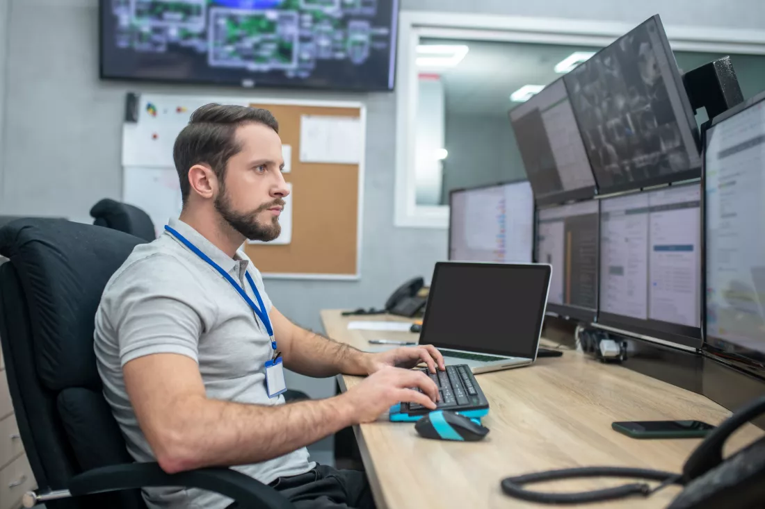 mindfulness-serious-young-bearded-man-sitting-workplace-looking-computer-screens-his-hands-keyboard
