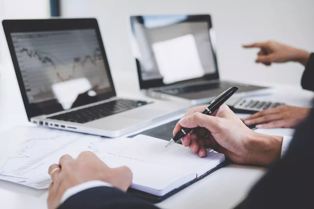 business-colleagues-working-with-laptop-discussing-analysis-graph-stock-market-trading