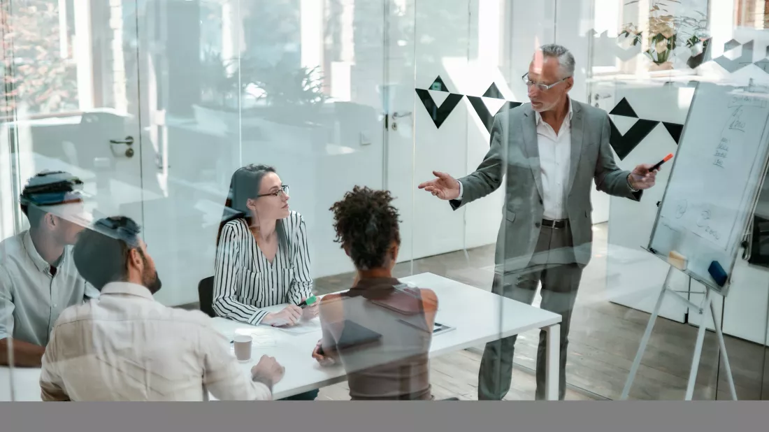 discussing-new-project-mature-businessman-standing-near-whiteboard-pointing-it-while-his